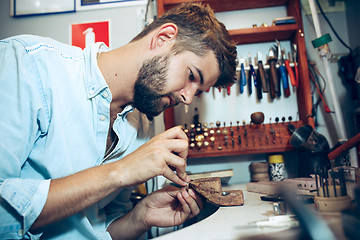 Image showing Different goldsmiths tools on the jewelry workplace. Jeweler at work in jewelry.