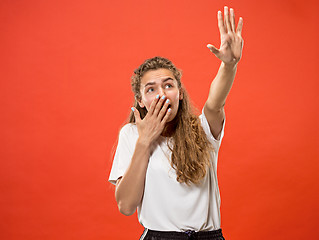 Image showing Portrait of the scared woman on red