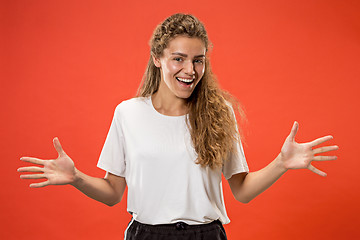 Image showing Beautiful woman looking suprised isolated on orange