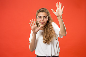 Image showing Portrait of the scared woman on red