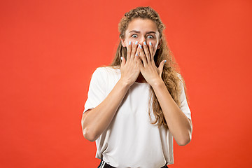 Image showing Beautiful woman looking suprised isolated on orange