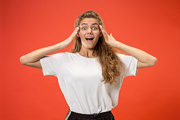 Image showing Beautiful woman looking suprised isolated on orange