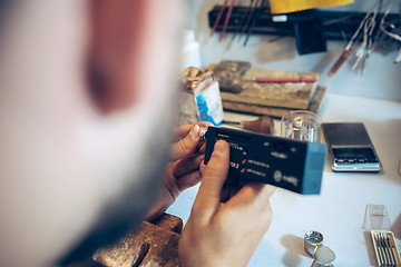 Image showing Different goldsmiths tools on the jewelry workplace. Jeweler at work in jewelry.