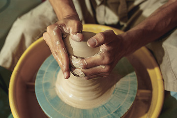 Image showing Creating a jar or vase of white clay close-up. Master crock.