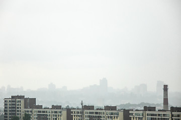 Image showing A view of the new houses against the background of the silhouettes of buildings in the misty sky.