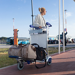 Image showing Young woman transporting luggage from arrival parking to international airport departure termainal by luggage trolley.