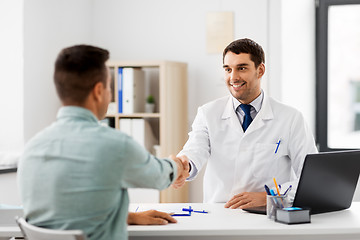 Image showing doctor and male patient shaking hands at hospital