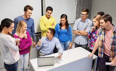 Image showing students and teacher with papers and laptop