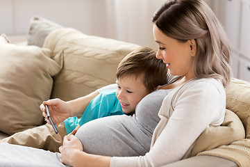Image showing pregnant mother and son with smartphone at home
