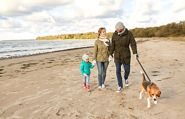 Image showing happy family walking with beagle dog on beach