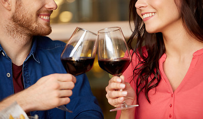 Image showing happy couple drinking red wine at restaurant