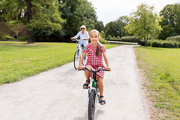 Image showing grandmother and granddaughter cycling at park