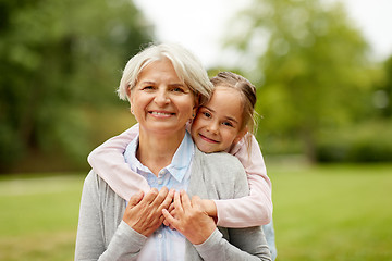 Image showing granddaughter hugging grandmother at summer park