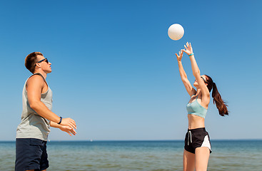 Image showing happy couple playing volleyball on summer beach