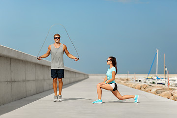 Image showing happy couple warming up on pier before training