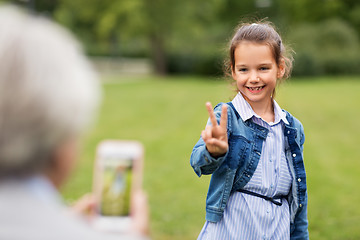 Image showing girl being photographed and showing peace sign