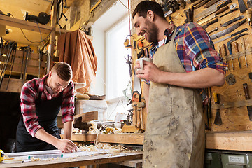 Image showing carpenters with ruler and coffee at workshop