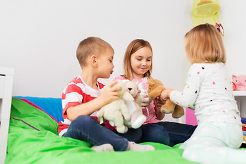 Image showing happy children playing with soft toys at home