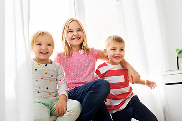 Image showing happy little kids hugging at window