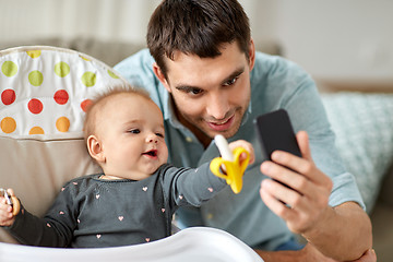 Image showing father with baby daughter taking selfie at home