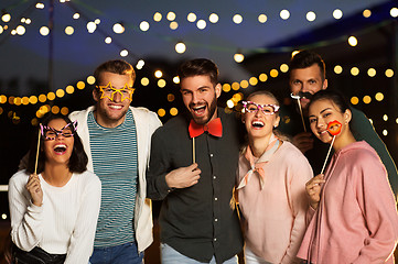 Image showing happy friends with party props at rooftop