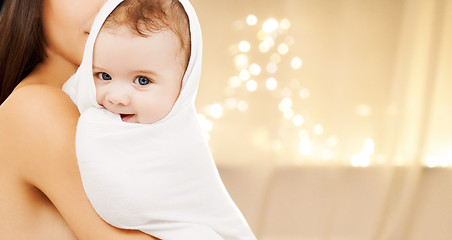 Image showing close up of mother with baby over christmas lights