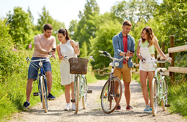 Image showing couple with bicycles and smartphone in summer