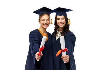 Image showing female graduates in mortar boards with diplomas