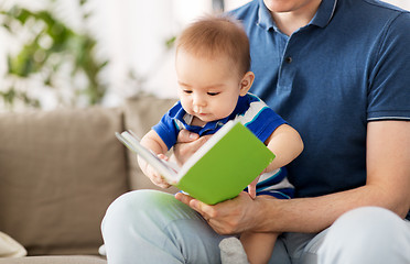 Image showing baby boy and father with book at home