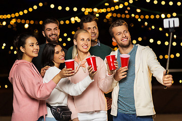Image showing friends with drinks taking selfie at rooftop party