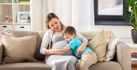 Image showing happy pregnant mother and son hugging at home