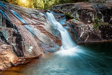 Image showing Lush slip slide waterfall into swimming hole