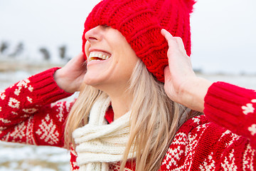 Image showing Happy woman outdoors pulling beanie over eyes