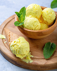 Image showing Golden colored turmeric ice cream in wooden bowl.