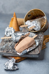 Image showing Homemade ice cream with chocolate icing on a stick.