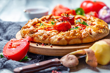 Image showing Open pie with potatoes, bacon, onions and tomatoes.