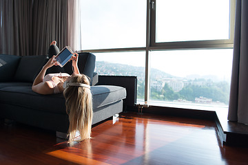 Image showing Lovely Blond Woman Listening To Music while resting on couch