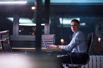 Image showing man working on laptop in dark office