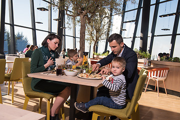 Image showing Young parents enjoying lunch time with their children