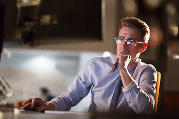 Image showing man working on computer in dark office