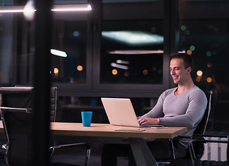 Image showing man working on laptop in dark office