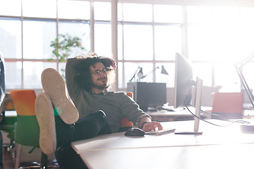 Image showing businessman sitting with legs on desk