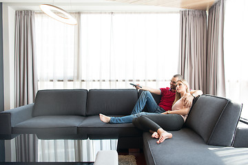 Image showing Young couple on the sofa watching television