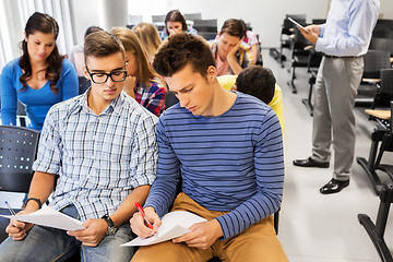 Image showing group of students with papers in lecture hall