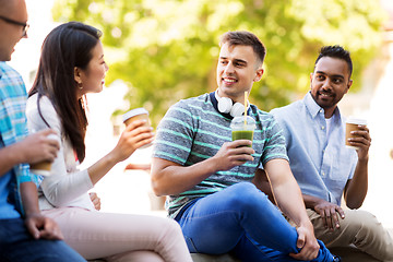 Image showing friends drinking coffee and juice talking in city