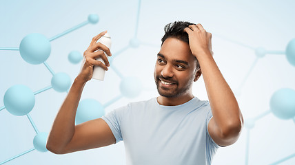 Image showing smiling indian man applying hair spray