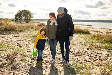 Image showing happy family walking along autumn beach