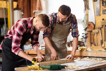 Image showing carpenters with ruler and wooden board at workshop