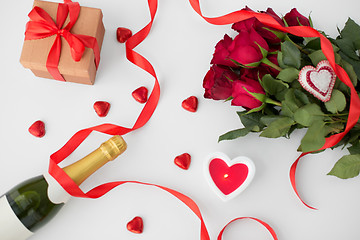 Image showing close up of champagne, gift, candies and red roses