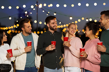 Image showing friends with party cups on rooftop at night